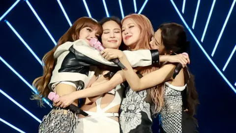 Blackpink members embrace during concert