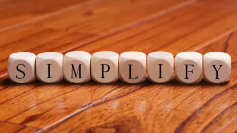 Getty Images SIMPLIFY word wooden blocks are on the floor.