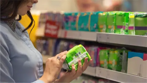 Getty Images Woman choosing sanitary product in supermarket