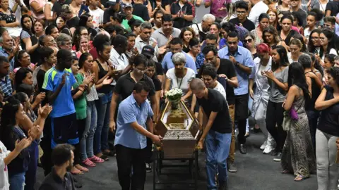 AFP/Getty Images The coffin of one of the victims of the Raul Brasil public school shooting is wheeled by mourners