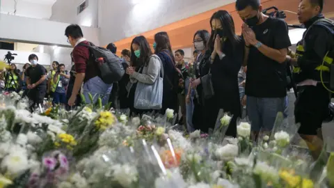 EPA Crowds leave flowers in tribute to Mr Chow