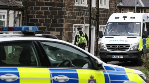 PA Media Police officer walking past the house