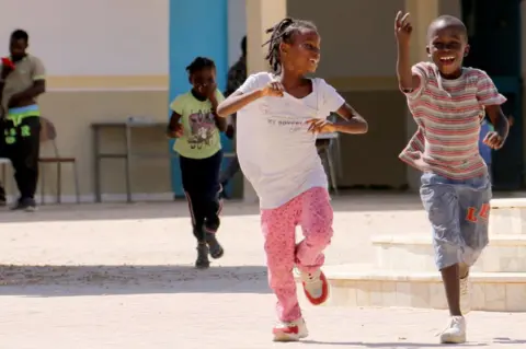 Fathi Nasri/AFP Boys and girls play in a courtyard.
