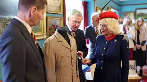 PA Media Queen Camilla views the tunic