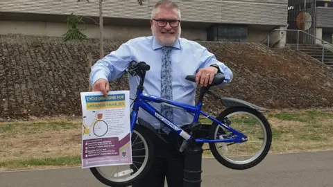 Bedford Borough Council Mayor Dave Hodgson holding a bike up