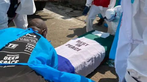 People moving a coffin