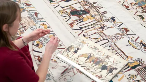 PA/Joe Giddens Mia Hansson with her unfinished recreation of the Bayeux Tapestry