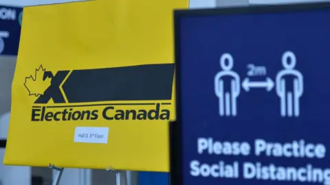 NurPhoto via Getty Images) COVID-19 and Elections Canada related signs seen inside Edmonton Expo Center hall