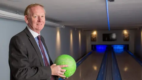 SWNS Graham Wildin holding a bowling ball