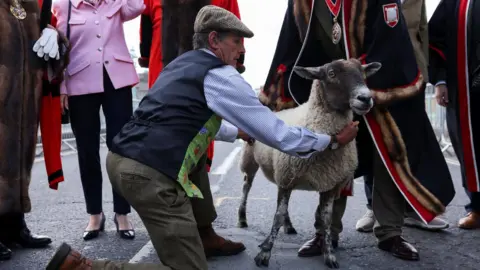 Reuters Sheep farmer David Seamark holds a sheep named Chino on the day of the annual London Sheep Drive