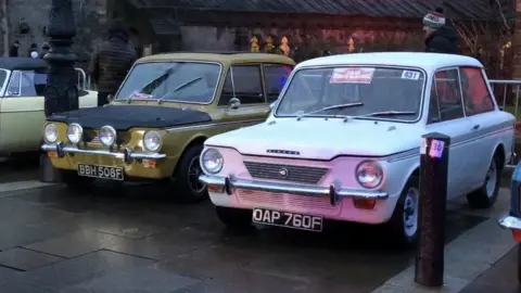 Two cars competing in the rally on display