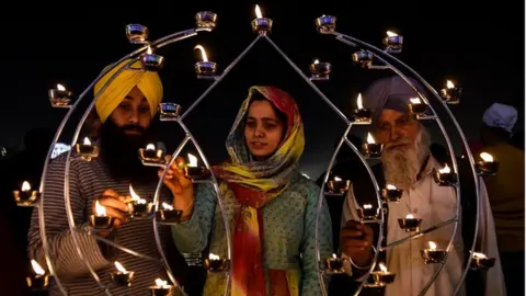 Getty Images Sikh devotees light candles on the occasion of Bandi Chhor Divas