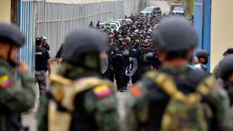 AFP Ecuadorean soldiers and policemen take positions outside of the Regional 8 prison, next to the penitentiary, in the outskirts of Guayaquil, Ecuador, on October 2, 2021.