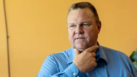 Getty Images Jon Tester holds hand to face, wearing a blue shirt