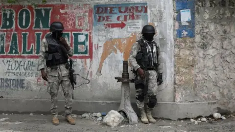 Reuters Members of the Haitian National Police patrol a street as ongoing gun battles between rival gangs have forced residents to flee their homes, in Port-Au-Prince, Haiti April 28, 2022