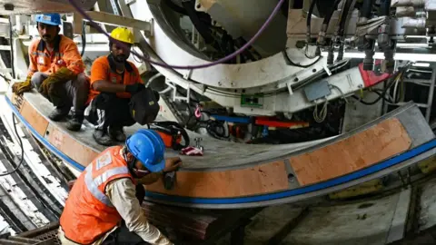 Getty Images Labourers launch a tunnel boring machine (TBM) known as 'Pelican' at the 'Chennai Metro Rail project' in Chennai on 31 January 2024