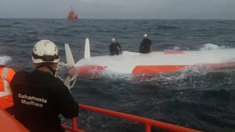 Reuters A Spanish crew from Salvamento Maritimo rescue a French sailor from under a capsized boat after 16 hours at sea off the coast of Malpica, A Coruna, in the Spanish north-western Galicia region, Spain August 2, 2022. Salvamento Maritimo/Handout via REUTERS THIS IMAGE HAS BEEN SUPPLIED BY A THIRD PARTY. MANDATORY CREDIT. NO RESALES. NO ARCHIVES