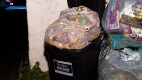 BBC Guernsey food waste container overflowing and recycling bag