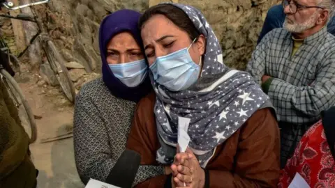 Getty Images Wife of slain Mudasir Gull weeps and pleads during a protest demanding the return of the bodies of Altaf and Mudasir Gull