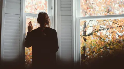 Getty Images picture of lady looking out of a window