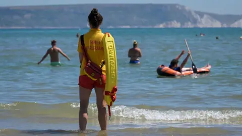 Getty Images A RNLI lifeguard patrols a beach in Weymouth, England