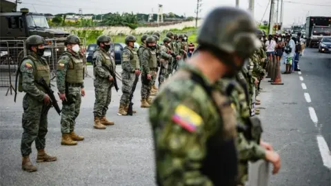 Reuters Soldier stand guard outside a prison where inmates were killed during a riot that the government described as a concerted action by criminal organisations, in Guayaquil, Ecuador February 23, 2021.