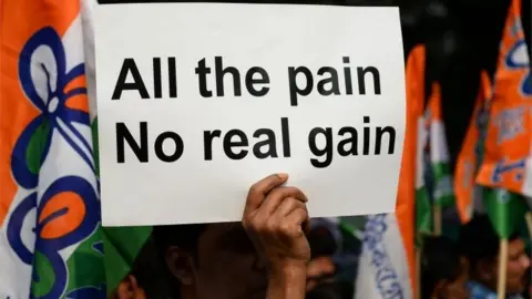 AFP An Indian supporter of the Chief Minister of the state of West Bengal and leader of the opposition Trinamul Congress (TMC) party Mamata Banerjee holds a placard as she delivers a speech during a protest against demonetisation in New Delhi on November 23, 201