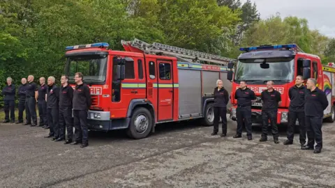 NYFRS Fire crews stand in front of engine