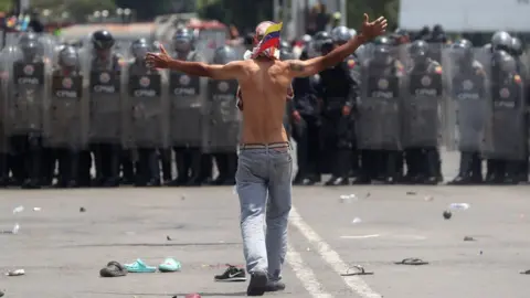 EPA Opposition protesters face Venezuelan police at the Simón Bolívar International Bridge in Cucuta, Colombia. Photo: 23 February 2019