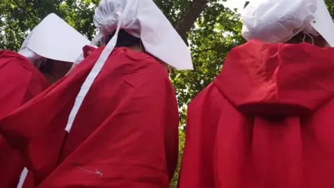 Isabel Marler protesters dressed as handmaids during anti-Trump protests in London