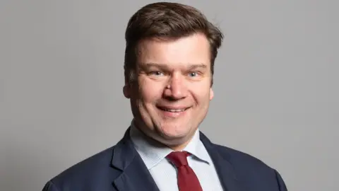 Man smiling in suit and tie