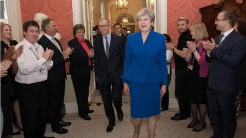 PA Theresa May is welcomed back to Downing Street after accepting an invitation to form a government
