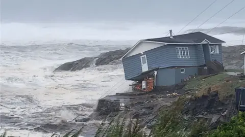 Reuters A house looks about to fall into the sea