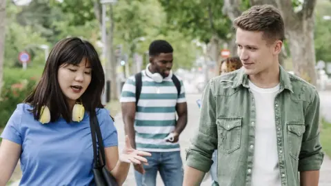 Getty Images Friends walking in the street