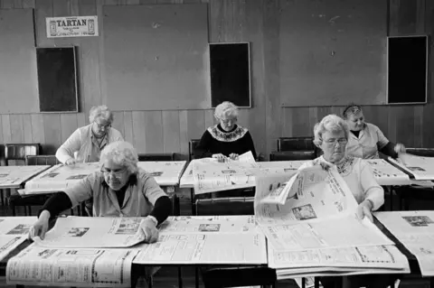 Glyn Satterley On Thursdays, women hand-fold and assemble The Northern Times in a Golspie hotel'