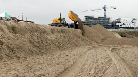 sand cliffs being flattened