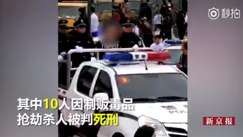 Beijing News A criminal on the back of a police car