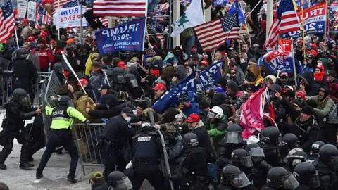 Getty Images Trump supporters clash with police and security forces as they push barricades to storm the US Capitol