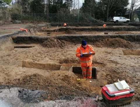 Cotswold Archaeology An archaeologist investigating the relationship between two phases of boundaries aligned with the boundary of St Michael’s Church