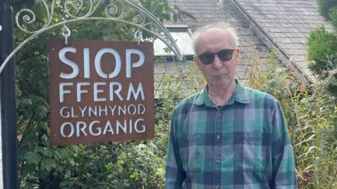 John outside his farm shop