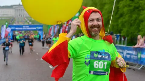 a man runs in the marathon in a bright costume