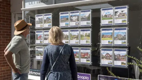 Getty Images Couple looking at estate agent window