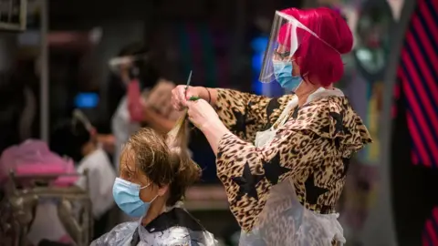 Getty Images Hairdresser Carole Rickaby cuts her client Sandra Jacobs' hair shortly after midnight on Saturday