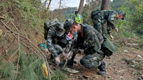 Reuters Paramilitary police search the site of the China Eastern Airlines crash