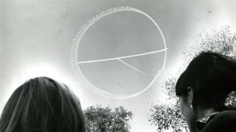 Getty Images A small skywriting plane draws the peace symbol in the clear blue sky over Boston Common