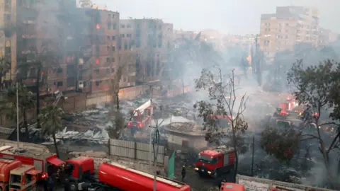 EPA-EFE/REX/Shutterstock Firefighters try to extinguish a fire at bulding near Al-Ahram Studio in Giza, Egypt, 16 March 2024.