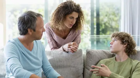 Getty Images A stock image of parents talking to teenage son