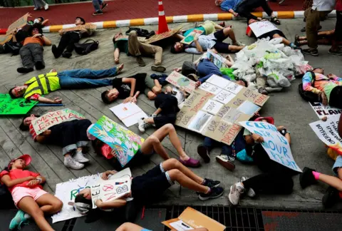 Reuters Activists play dead on the floor with banners