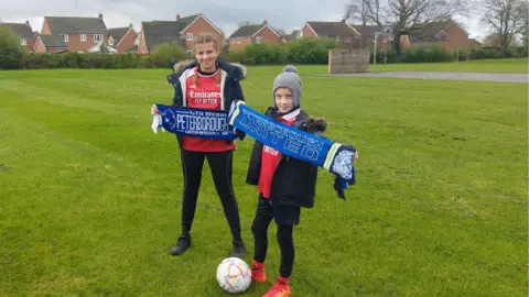 Kieran Chatten Emilia, 13, and Jakub, 8, holding Peterborough United scarves