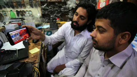 EPA People in Peshawar watch the news of Mr Khan being granted bail at Islamabad High Court